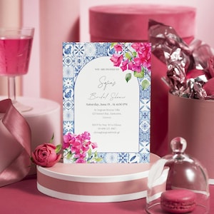 Könnte beinhalten: Ein blauer und weißer Fliesenrand umrahmt eine weiße Einladung mit dem Text "You are invited to Sofia's Bridal Shower" in kursiver Schrift. Die Einladung enthält Datum, Uhrzeit und Ort der Veranstaltung. Im oberen rechten Eck der Einladung befinden sich rosa Blumen.