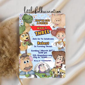 May include: A colorful birthday invitation featuring cartoon characters. The invitation reads "You've Got a Friend Who's Three" and includes the name "Robert" and party details. The design includes images of a dinosaur, a pig, a dog, a cowgirl, a potato head, and a cowboy.