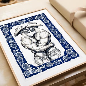 May include: A framed art print featuring a black and white ink illustration of two muscular figures wearing cowboy hats and jeans, embracing closely. The central illustration is enclosed by a decorative border of dark blue flowers and foliage.