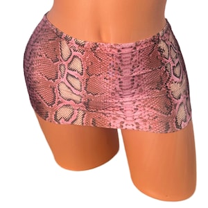 May include: A mini skirt with a pink and brown snakeskin pattern. The skirt is made of a lightweight material and has a fitted silhouette. The skirt is designed to sit high on the waist.