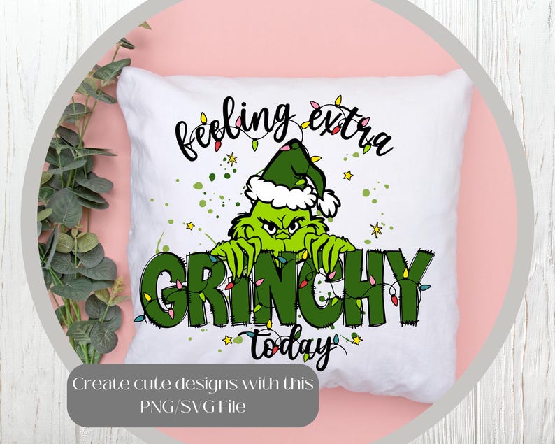 May include: White square pillow with a Grinch design. The Grinch is green and wearing a Santa hat. The words "feeling extra GRINCHY today" are written on the pillow in black and green. The design includes Christmas lights and stars.