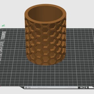 May include: A brown cylindrical container with a hexagonal pattern on the exterior. The container is sitting on a black and white grid.