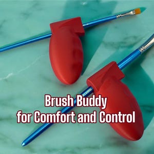 May include: Two paint brushes with blue handles and red brush holders. The brushes have yellow bristles and are positioned on a teal surface. The text "Brush Buddy for Comfort and Control" is displayed.