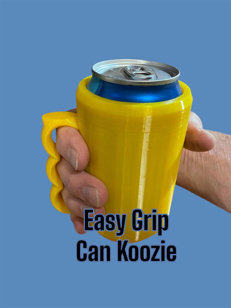 K&ouml;nnte beinhalten: Ein gelber Easy Grip Can Koozie h&auml;lt eine blau-silberne Dose. Der K&uuml;hler hat einen Griff mit Fingerrillen. Der Text "Easy Grip Can Koozie" ist auf der Vorderseite des K&uuml;hlers aufgedruckt.