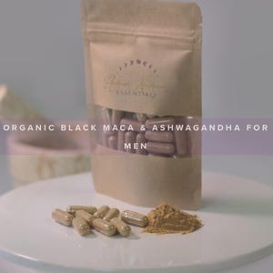 May include: A brown paper bag with a white label that says "Ritual Alchemy Essentials". The bag is filled with brown and purple capsules. The text "ORGANIC BLACK MACA & ASHWAGANDHA FOR MEN" is visible on the bag. There are also brown capsules and a pile of brown powder on a white surface.