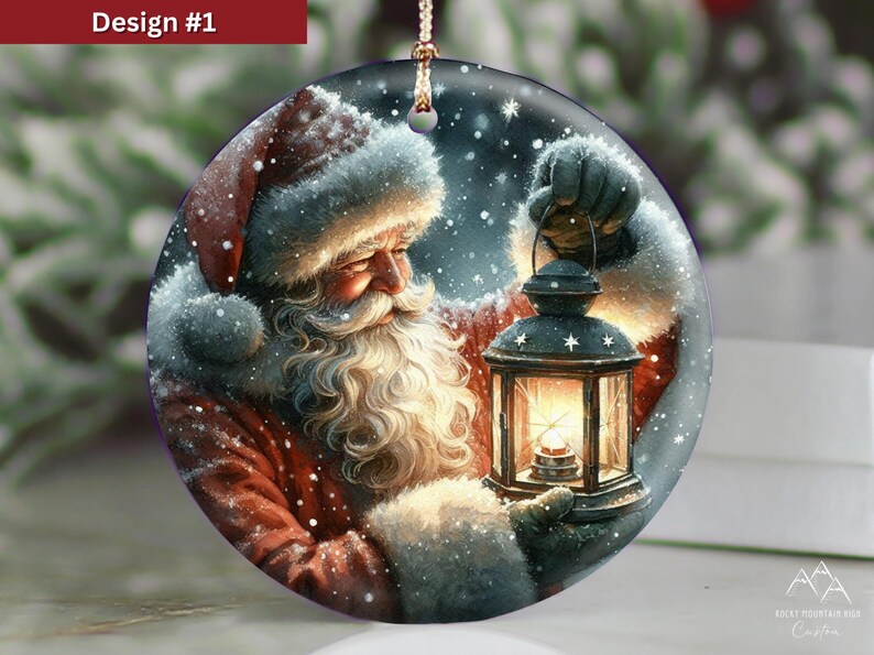 Puede incluir: Un adorno redondo de cer&aacute;mica con una ilustraci&oacute;n detallada de Santa Claus con barba blanca y traje rojo, sosteniendo una linterna brillante. La escena incluye nieve cayendo sobre un fondo oscuro, con un cord&oacute;n dorado en la parte superior.