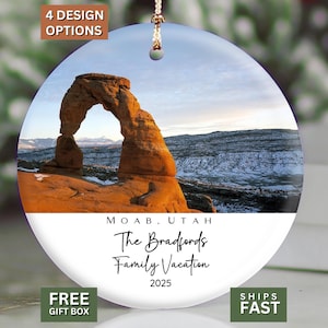 May include: A round ceramic ornament featuring a photograph of a rock arch in Moab, Utah. The ornament includes the text "The Bradfords Family Vacation 2025". The ornament has a string for hanging.