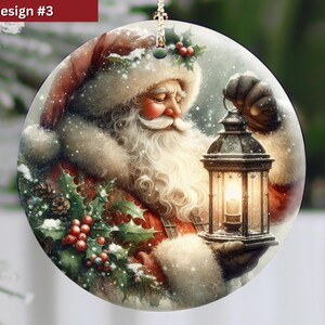 Puede incluir: Un adorno navide&ntilde;o redondo de cer&aacute;mica con una ilustraci&oacute;n detallada de Santa Claus con una larga barba blanca, vistiendo un abrigo y gorro rojos con ribete de piel blanca, sosteniendo un farol encendido y decorado con acebo y bayas rojas.