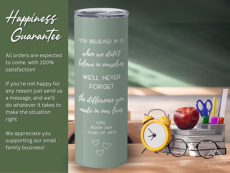 May include: A sage green tumbler with a silver lid, inscribed with white text. The text reads, "You believed in us... We'll never forget the difference you made in our lives." A yellow alarm clock, apple, and glasses are next to the tumbler.