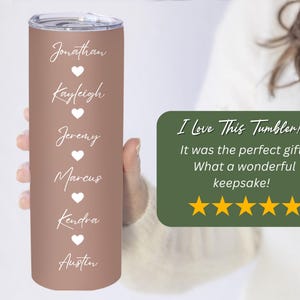 May include: A rose gold stainless steel tumbler with six names and hearts printed in white. The names are Jonathan, Kayleigh, Jeremy, Marcus, Kendra, and Austin. The tumbler is being held by a person's hand. The text "I Love This Tumbler! It was the perfect gift. What a wonderful keepsake!" is printed on a green background with five gold stars below the text. The text "Rocky Mountain Fig Custom" is printed below the stars.