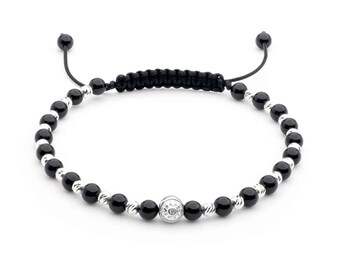 Peut inclure: Bracelet en onyx noir et perles argentées avec un charme argenté orné d'un motif en forme de diamant. Le bracelet est doté d'une fermeture en cordon noir.