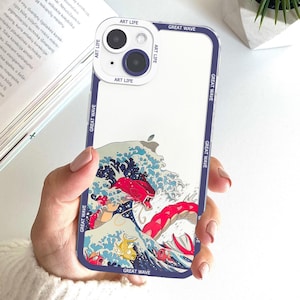 May include: Clear phone case with a blue border featuring a Japanese wave design with red and blue creatures. The case has the words "ART LIFE" and "GREAT WAVE" printed on it.