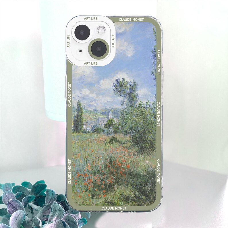 May include: A phone case featuring a landscape painting by Claude Monet. The case has a clear border with the text "CLAUDE MONET" and "ART LIFE" printed on it. The artwork depicts a field of flowers and trees under a blue sky.
