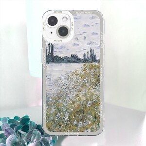 May include: A clear phone case featuring a landscape painting in the style of Claude Monet. The artwork depicts a river scene with trees and foliage in shades of green, white, and gray. The case has the text "ART LIFE" and "CLAUDE MONET" printed on it.