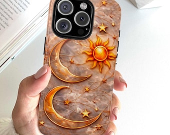 May include: A phone case with a celestial design featuring a sun, crescent moons, and stars in gold against a marble-like background. The case has a glossy finish and a protective design.
