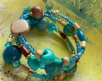 beaded wrap bracelet with hand-painted beads in light blue and aqua, includes a tassel, wood, and glass with a funky vibe