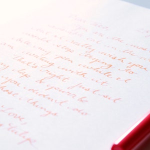 May include: A close-up of a handwritten note on white paper with a pink pen. The note reads: "25 July 2017. I really wish for you to come & stop crying so I can write my pen while I am crying with it. That's right just sit on my lap & you'll pretend you didn't do any of those things. Love, Chewy tutape"
