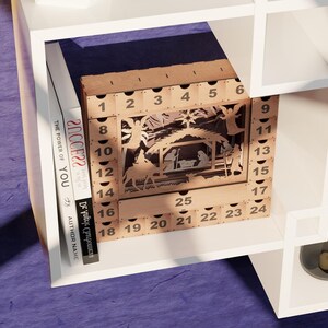 Light wooden advent calendar displayed on a white shelving unit next to books with visible text spines.