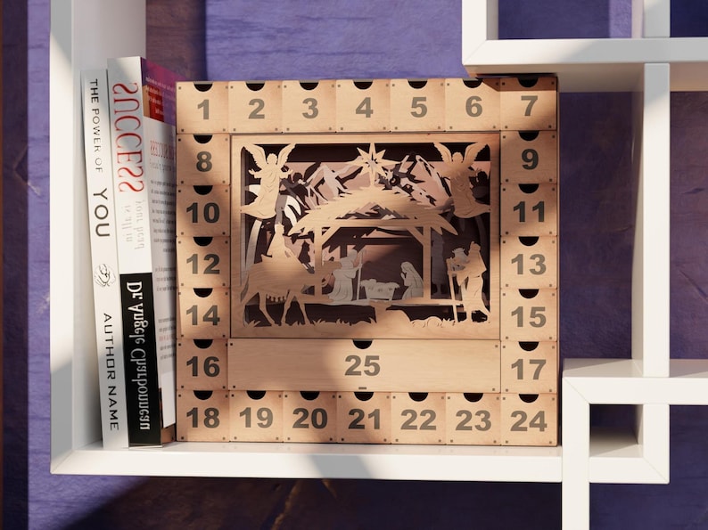 Light wooden nativity advent calendar positioned on a white shelving unit beside books.