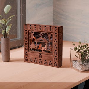 Dark wooden nativity advent calendar sitting on a wooden desk next to potted plants and a window.