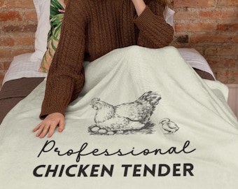 Può includere: Una coperta bianca con un'illustrazione in bianco e nero di una gallina e un pulcino. Il testo "Professional Chicken Tender" è stampato in nero sotto l'illustrazione.