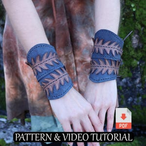 May include: Blue leather wrist cuffs with brown leaf-shaped cutouts. The cuffs are worn on both wrists. The image includes the text "PATTERN & VIDEO TUTORIAL" and a PDF icon.