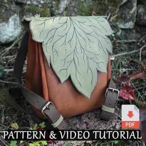 Może przedstawiać: Brązowy skórzany plecak z zieloną klapą w kształcie liścia. Plecak ma regulowane paski i zapięcie na klamrę. Obraz zawiera tekst "PATTERN & VIDEO TUTORIAL" i ikonę pobierania z tekstem "PDF".