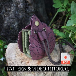 Op de afbeelding: Een handgemaakte blad-vormige portemonnee in paars en groen leer, met een trekkoord sluiting. De portemonnee heeft gedetailleerde bladnerfpatronen. De tekst "PATTERN & VIDEO TUTORIAL" is inbegrepen.
