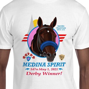 Puede incluir: Camiseta blanca con un gr&aacute;fico de cabeza de caballo en un c&iacute;rculo rosa, rayas rojas y blancas y texto. El texto incluye "MEDINA SPIRIT Derby Winner!" y "147th May 1, 2021".