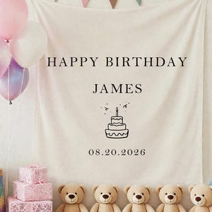 May include: A birthday party backdrop featuring a banner with "HAPPY BIRTHDAY JAMES" and the date 08.20.2026. The scene includes balloons, teddy bears, gift boxes, and a decorative basket. A garland of colorful flags hangs above.