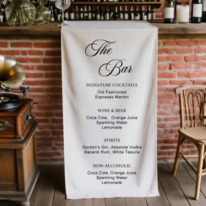 以下が含まれることがあります： 「The Bar」の文字とドリンクメニューが書かれた白い布がかけられたバー。メニューにはカクテル、ワイン、ビール、スピリッツ、ソフトドリンクが記載されています。ヴィンテージのレコードプレーヤーと花も見えます。