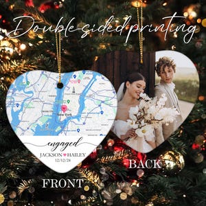 May include: A white heart-shaped ceramic ornament with a map of New York City on the front and the text "engaged JACKSON ♥ HAILEY 12/12/24". The back of the ornament features a photo of a couple in wedding attire.