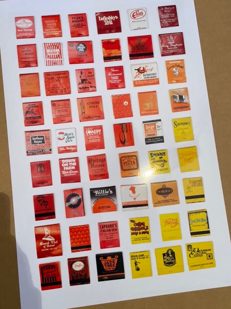May include: A collection of 49 vintage matchbook covers, mostly red, with various business names and logos. The matchbooks are arranged in a grid on a white background.
