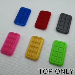 May include: Six different colored plastic ice cube trays. The trays are all the same size and shape, and they each have nine compartments. The colors of the trays are blue, red, gray, pink, gold, and green.