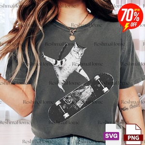 May include: Dark grey t-shirt featuring a black and white graphic of a cat skateboarding. The cat is mid-air, with arms outstretched. The skateboard has a cartoon design. The shirt has the text "Reshma Home".