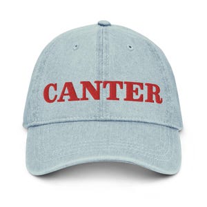 May include: A light blue denim baseball cap with the word "CANTER" embroidered in red.
