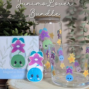 May include: A Junimo Lover Bundle featuring a glass jar, a drinking glass, and magnetic bookmarks. The items are decorated with colourful Junimo characters and star-shaped flowers. The text "Junimo Lover Bundle" is displayed at the top.