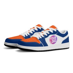 May include: A pair of low-top sneakers with a white base, blue accents, and orange detailing. The right shoe features a logo that says "YOUR LOGO" in a gradient of pink and purple.