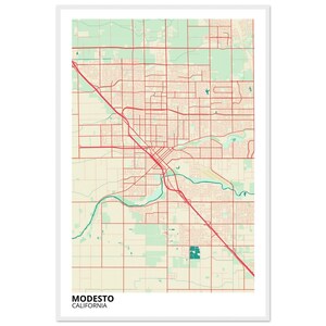 May include: A framed map print of Modesto, California. The map features a network of red roads and streets over a beige background, with green and blue accents representing parks and waterways. The city name and state are printed in black at the bottom.