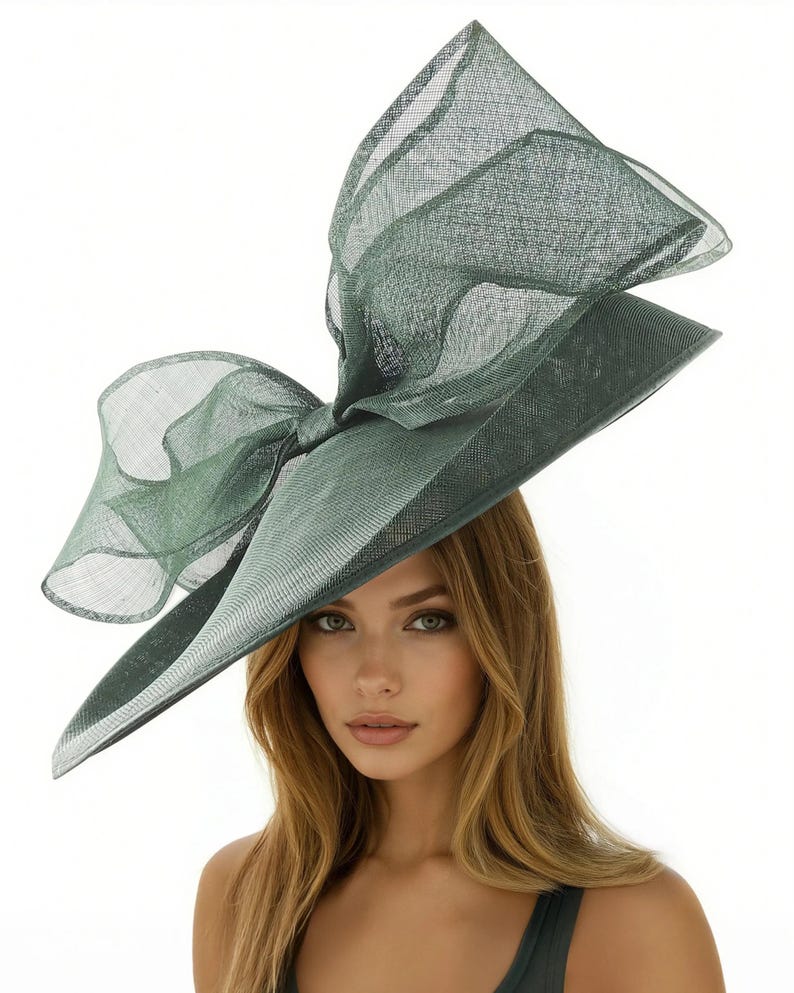 Puede incluir: Un sombrero verde elegante con un gran lazo. El sombrero presenta un ala ancha y un dise&ntilde;o estructurado, ideal para ocasiones especiales. El color es un verde apagado y sofisticado.