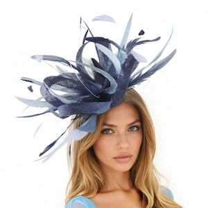 May include: A navy blue and light blue fascinator with feathers. The headpiece features a structured base with a ribbon design and is adorned with various shades of blue feathers. This elegant accessory is suitable for special occasions.