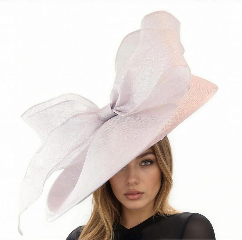 Puede incluir: Un sombrero lila claro con un gran lazo. El sombrero tiene un ala ancha y est&aacute; hecho de una tela transparente y ligera. El lazo es el punto focal, agregando un toque de elegancia. Adecuado para ocasiones especiales.