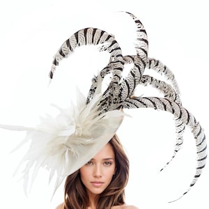 May include: A white hat with a large, white feather plume and a black and white striped feather accent.