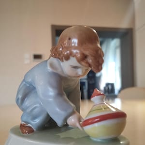 Porcelain figurine &quot;Boy with a spinning top&quot;. Manufactured by ZSOLNAY (Hungary)
