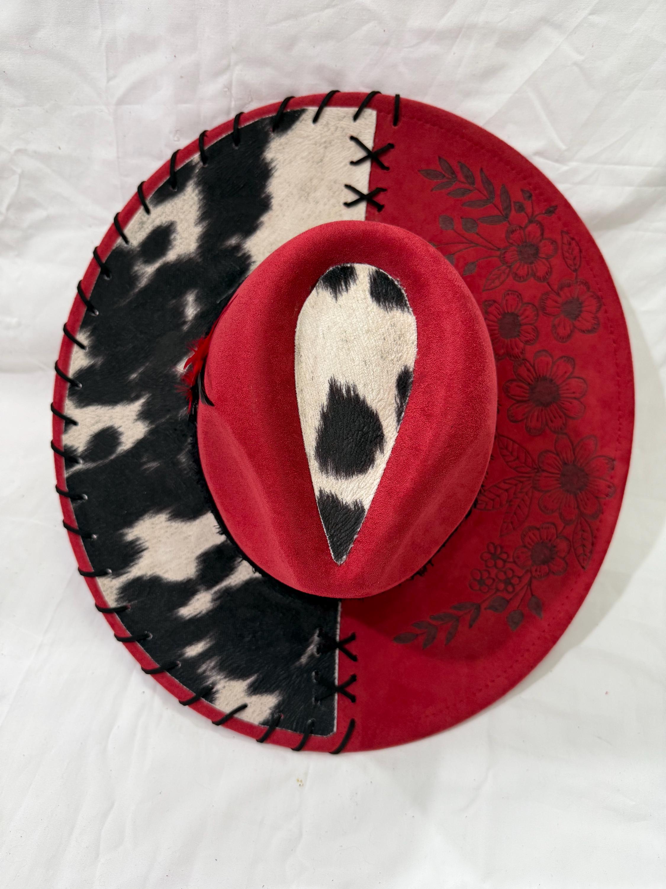 Red wide brim hat, black/white cowhide fabric, flowers burned on brim, black band, red/black feathers, black leather lacing.