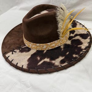 Brown Wide Brim Hat: Brown/White Cowhide Fabric With Brown Leather Lacing And Flowers Burned On Brim Brown Hat Band With Feathers