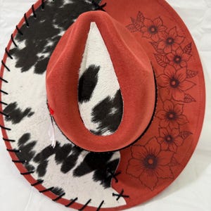 Hand Burned Wide Brim Hat Burnt Orange: Cowhide Fabric With Black Leather Lacing And Flowers Burned On Brim With Black Hat Band And Feathers