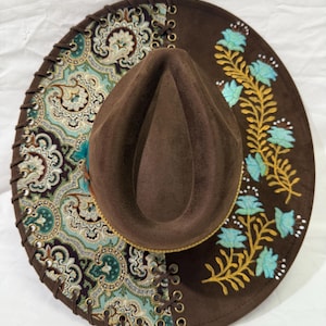 Custom hand burned brown wide brim hat, green/brown/gold fabric with leather lacing and flowers burned/painted on brim.