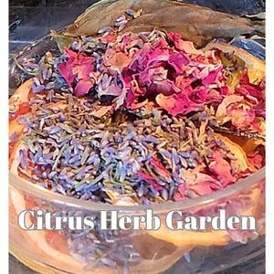 Puede incluir: Un bol de vidrio lleno de fruta cítrica seca, lavanda y pétalos de rosa. El bol está etiquetado como "Citrus Herb Garden".