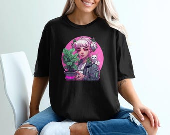 Può includere: Una maglietta nera con una stampa grafica di una ragazza anime dai capelli rosa che tiene una pianta in vaso e un gatto bianco. La grafica è posizionata su un cerchio rosa con un contorno bianco.